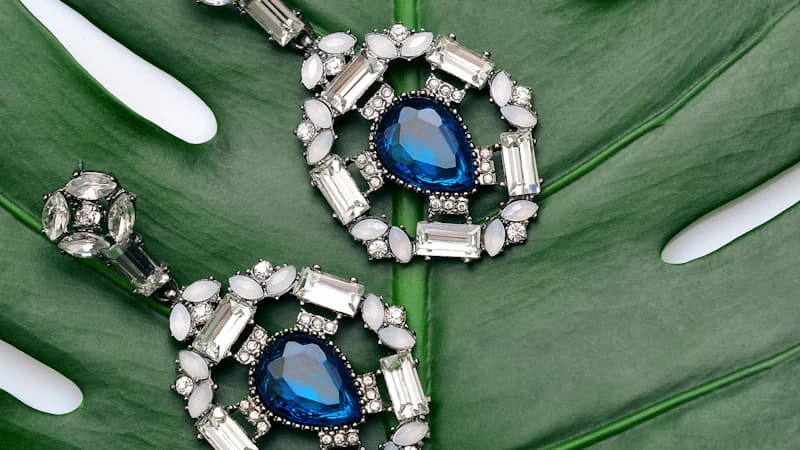 Velvet-lined rigid jewelry box in deep navy with gold foil branding